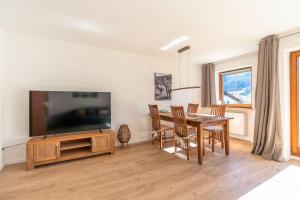 a living room with a dining room table and a flat screen tv at Bergluft in Bad Hindelang