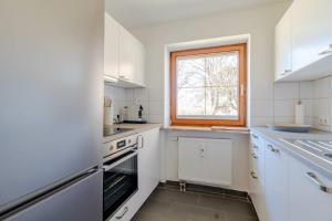 a kitchen with white appliances and a window at Bergluft in Bad Hindelang