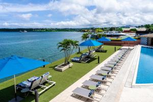 an image of a resort with a pool and chairs and umbrellas at Grand Hotel & Casino in Port Vila