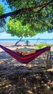 a person laying in a hammock on a beach at Cabaña y restaurante vikana in Nuquí +122 photos