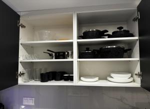 a white cabinet filled with dishes and pots and pans at Blue Sea Nest in Paralia Katerinis