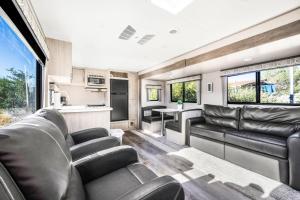 a living room with leather couches and a kitchen at De Anza Springs Resort in Titus