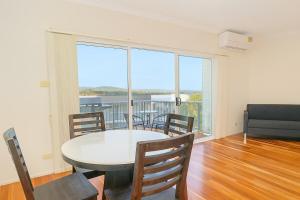 a dining room with a table and chairs and a large window at Modern 2BR Townhouse with BBQ & Pool Access in Muswellbrook