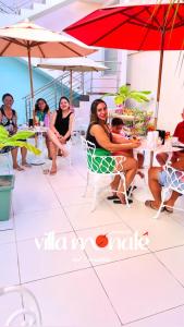 a group of women sitting at a table under an umbrella at Pousada Villa Monale in Barreirinhas +6 photos