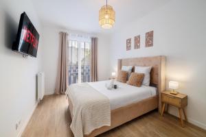 a bedroom with a bed with a tv and a window at 2 Bedroom Apartment for 6 with Private Parking - Elevator - High-Speed WiFi in Champigny-sur-Marne