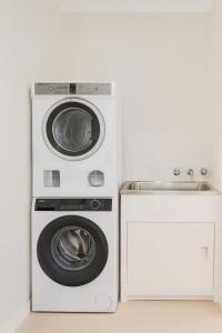 a washer and dryer next to a washing machine at Modern 2BR Townhouse with BBQ & Pool Access in Muswellbrook