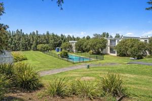 a large yard with a swimming pool and a house at Modern 2BR Townhouse with BBQ & Pool Access in Muswellbrook