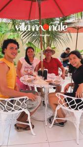 a group of people sitting at a table under an umbrella at Pousada Villa Monale in Barreirinhas