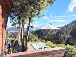 a house with a swimming pool and an umbrella at AIKA Reserva Glamping Tabio in Tabio