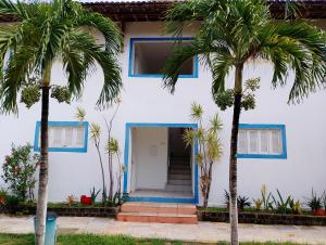 a white house with palm trees in front of it at residencial portuguesa in Parnamirim +9 photos