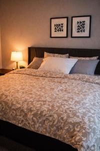 a bedroom with a large bed with pillows at NorthEdge Suites Leduc in Leduc