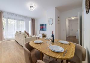 a dining room and living room with a wooden table at 2 Bedroom Apartment for 6 with Private Parking - Elevator - High-Speed WiFi in Champigny-sur-Marne +16 photos