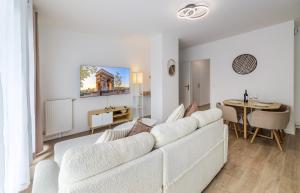 a living room with a white couch and a table at 2 Bedroom Apartment for 6 with Private Parking - Elevator - High-Speed WiFi in Champigny-sur-Marne