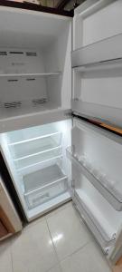 an empty refrigerator with its door open in a kitchen at Casa Andy a 5 min del aeropuerto de Veracruz in Veracruz