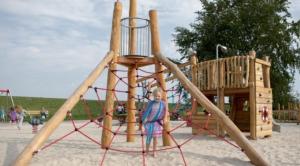 a woman standing in front of a playground at NordseeNest Varel in Varel