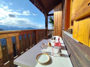 a table on a balcony with a view of the mountains at Le Doux Refuge in Ustou
