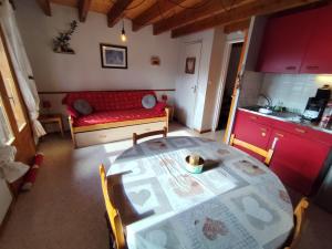 a living room with a table and a red couch at Le Doux Refuge in Ustou