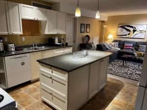 a kitchen with white cabinets and a living room at Cozy 2BR Getaway Quiet & Relaxing in Langley +13 photos