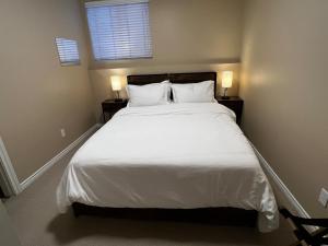 a bedroom with a large white bed with two lamps at Cozy 2BR Getaway Quiet & Relaxing in Langley