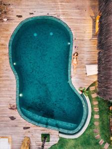 an overhead view of a woman swimming in a swimming pool at Villa Fulô in Caraíva