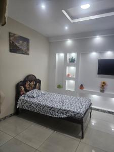 a bed in a room with a tv on the wall at Urban Oasis in Manta