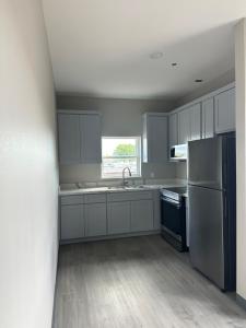a kitchen with white cabinets and a sink and a refrigerator at Super 8 by Wyndham Baytown in Baytown