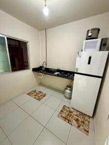 a kitchen with a refrigerator and a white tile floor at Angra Prime Centro in Angra dos Reis