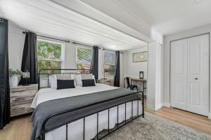 a bedroom with a large bed in a room with windows at NEW! Clearwater Gem, 10 Min to Beach, 2 Min to Downtown Dunedin, King Bed in Clearwater