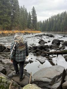 a person is standing on rocks near a river at Palooza Basecamp in Cascade