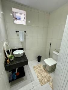 a white bathroom with a sink and a toilet at Angra Prime Centro in Angra dos Reis +1 photo