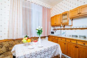 a kitchen with a table with fruits and flowers on it at Kozlov 9 Victory Square in Minsk