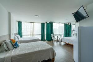 a hotel room with two beds and a refrigerator at Hospedaje Sary House in Bogotá +117 photos