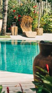 a vase sitting on a bench next to a swimming pool at Villa Fulô in Caraíva