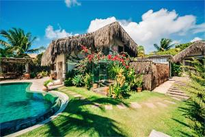 a house with a swimming pool and a resort at Villa Fulô in Caraíva