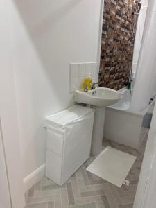 a white bathroom with a sink and a toilet at Zikach Apartment Near to Glasgow Airport in Renfrew