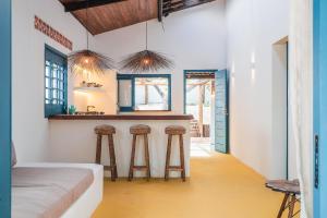 a kitchen with two bar stools in a room at Casa Pema - Grupo Casa Camurupim in Barra Grande +57 photos