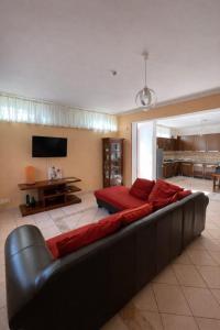 a large couch in a living room with a television at The Mazzitellis Home in Nettuno