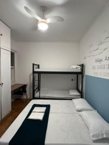 a bedroom with two bunk beds and a ceiling fan at Refugio Madalena Hostel in São Paulo