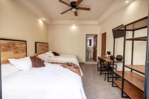 a bedroom with two beds and a ceiling fan at Casa María Teresa Suites in León +3 photos
