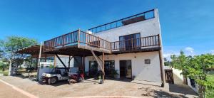 a house with a balcony on top of it at 4 Ventos House in São Miguel do Gostoso