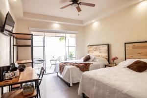 a bedroom with two beds and a table and a window at Casa María Teresa Suites in León