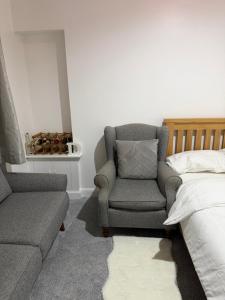 a bedroom with a couch and a chair next to a bed at Zikach Apartment Near to Glasgow Airport in Renfrew +25 photos