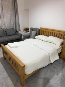 a bedroom with a large bed and a couch at Zikach Apartment Near to Glasgow Airport in Renfrew