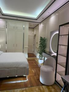 a bedroom with a bed and a chair at Damac Al Jawharah Tower Versace Sea View شقة فرزاتشي بإطلالة بحرية برج داماك الجوهرة in Jeddah +81 photos