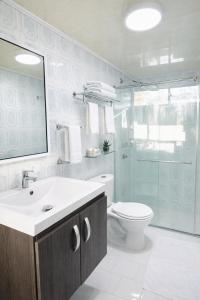 a bathroom with a sink and a toilet and a mirror at Posada Lkjay Providencia Isla in Providencia