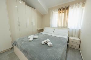a bedroom with a bed with two towels on it at koman_lakeview_apartments in Shkodër