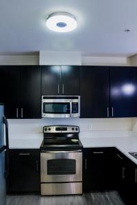 a kitchen with a stove and a microwave at Cozy & inviting 2BD 2BTH Apt Home in Owings Mills