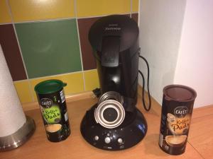 eine Kaffeemaschine und zwei Tassen auf der Theke in der Unterkunft Ferienwohnung Mitko in Radebeul