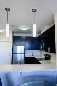 a kitchen with black cabinets and a stainless steel refrigerator at Cozy & inviting 2BD 2BTH Apt Home in Owings Mills +29 photos