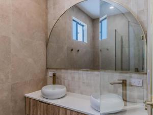 a bathroom with two sinks and a mirror at Black Wattle Beach House in Casuarina +36 photos